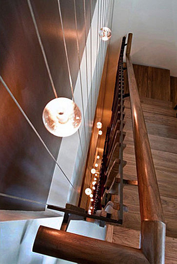 Thirty-three globe lights are suspended within the shallow space which separates the buildingâ€™s main stairway from the adjacent seven-story-high wall. The globes temporarily increase their light intensity in response to motion on the stairway.