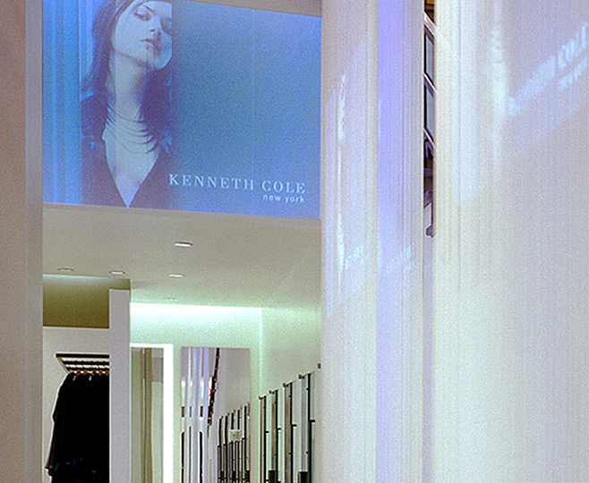 A 30-foot high scrim curtain visually connects the storeâ€™s two levels, while a row of spotlights placed between the layers of the scrim transforms it into a giant lighting element.  This back-lit curtain also serves as a projection screen.  Its dual function requires the scrimâ€™s illumination to be precisely balanced with the light level of the projected images.