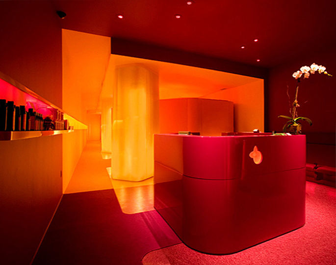 Yelo explores an entirely new concept in wellness services.  Combining reflexology with the benefits of a short nap, it helps urbanites deal with the pressures of modern life. The lighting concept is based on the power of color and light as a strong sensory stimulant.  The monochromatic ruby hue of the entry room gains vibrancy thanks to the reddish tint of the accent lights.  Further on, a yellow colored light emitted by the backlit enclosures of the column adds depth to the yellow-orange ambience of the hallway.